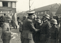 604539 Afbeelding van een Duitse officier die onderscheidingen uitreikt aan Duitse militairen ter gelegenheid van ...